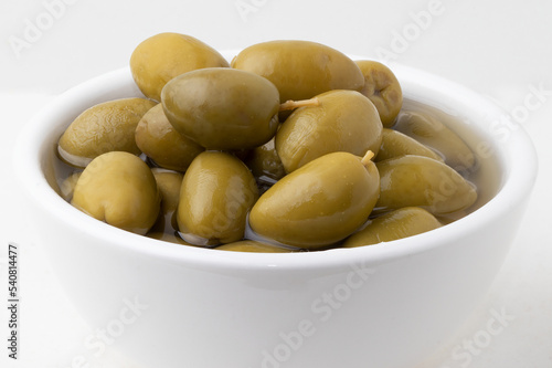 Olives in a white bowl close up.