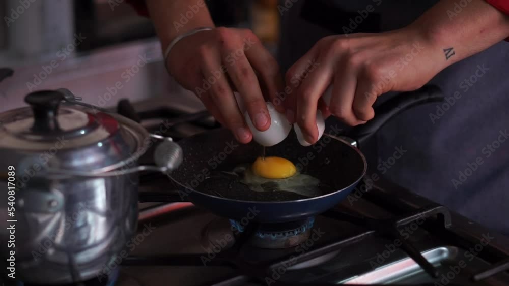 Hands of an unrecognizable person frying eggs in a frying pan. Hands of an unrecognizable person frying eggs in a frying pan.