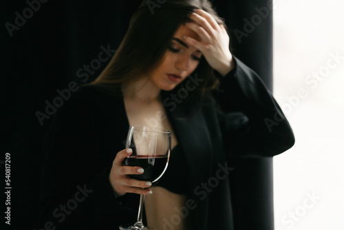 Fotografie Blurred of confident woman in formal suit holding glass of drink