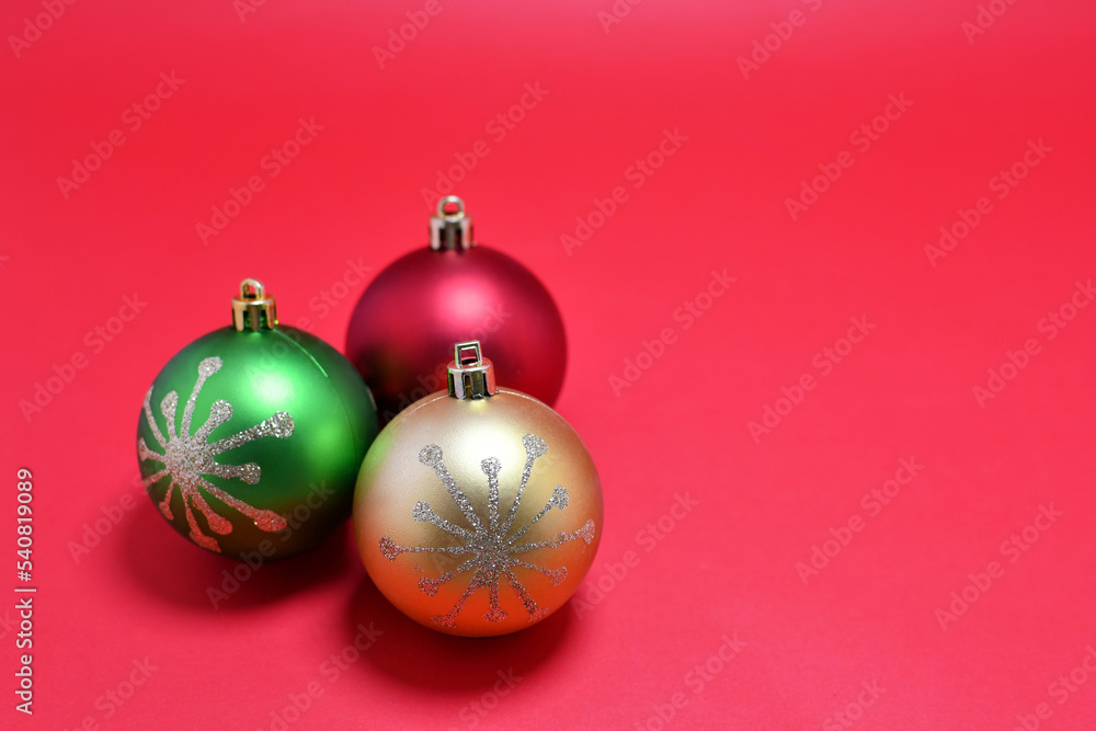 Esferas navideñas de colores, aisladas sobre fondo rojo. Espacio para texto al lado derecho. Esferas navideñas de colores, aisladas sobre fondo rojo. Espacio para texto al lado derecho.