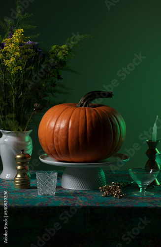 Pumpkin over a decorated table and green ambient light