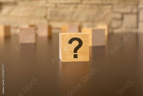natural wooden cube with question marks, grey background