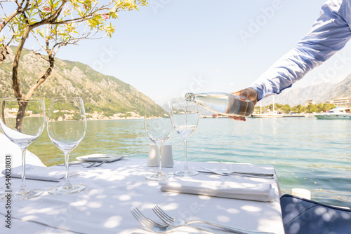 Foto Waiter pouring water from bottle in the restaurant