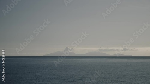 Scenic view of distant smoking volcano from ocean / Montserrat photo