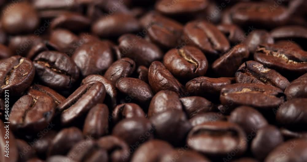 Roasted coffee beans dolly shot. Aromatic coffee beans move slowly. Slide slow motion close-up of whole roasted coffee beans. Roasted coffee beans dolly shot. Aromatic coffee beans move slowly. Slide slow motion close-up of whole roasted coffee beans.