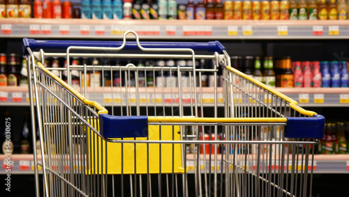 Close-up of a shopping trolley against light alcohol drinks background