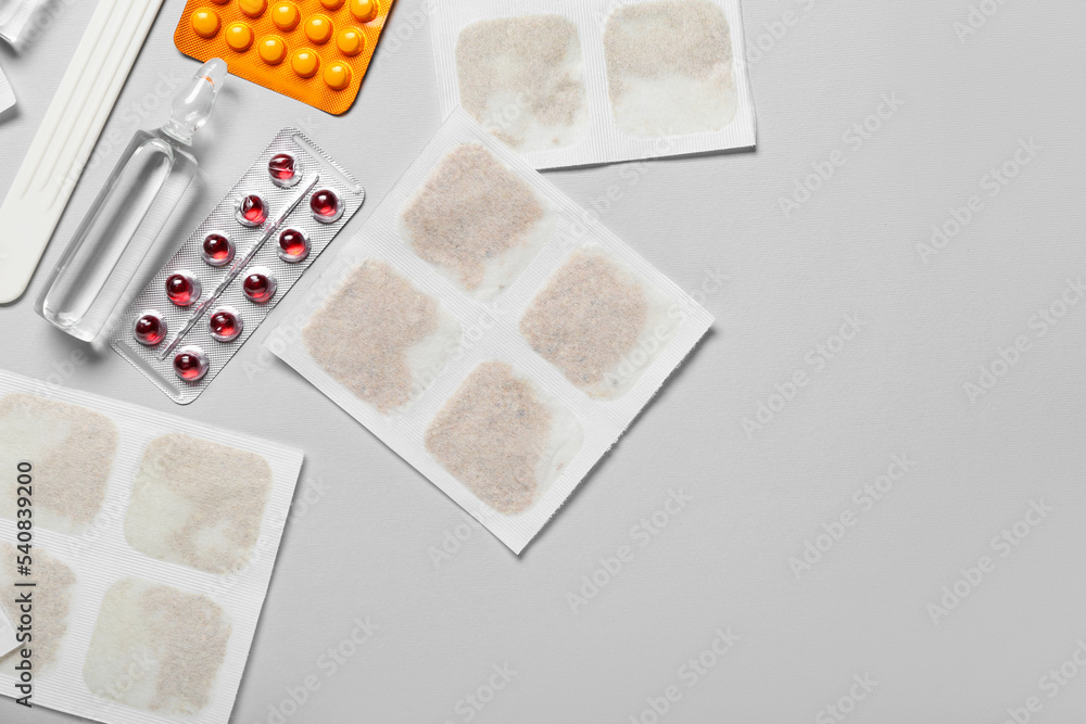 Mustard plasters with medicines on grey background Mustard plasters with medicines on grey background