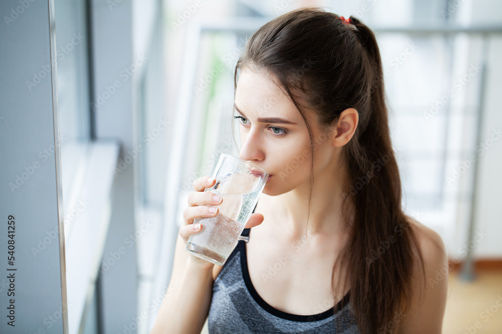 Smiling pretty woman holds a glass of water leaning Smiling pretty woman holds a glass of water leaning