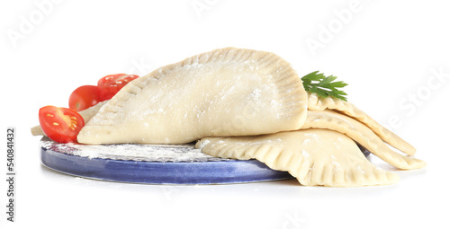 Board with raw chebureks, tomatoes and parsley on white background