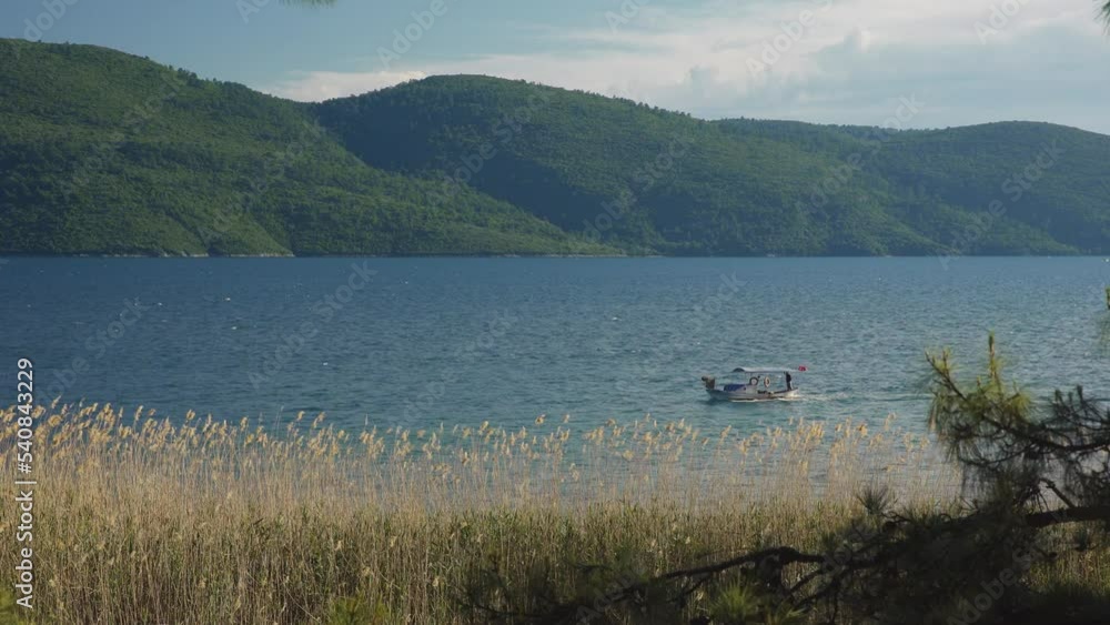 A fishing boat is passing by in blue Aegean coasts of Turkey. A fishing boat is passing by in blue Aegean coasts of Turkey.