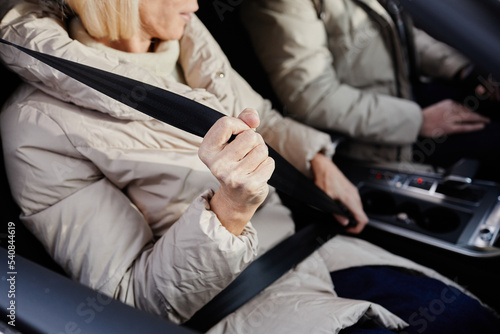 Close up of mature woman fastening seat belt in car  copy space