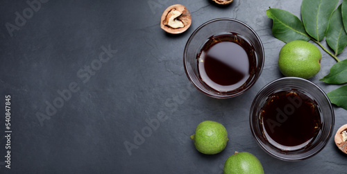 Bild auf Leinwand Delicious liqueur and fresh walnuts on black table, flat lay with space for text