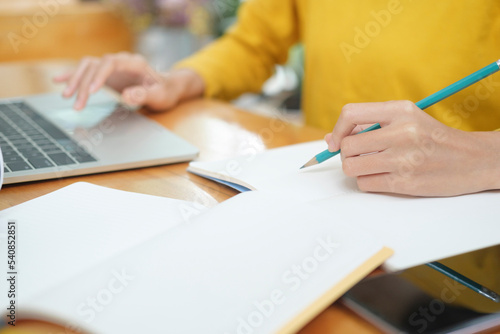 Close up of woman studying online using laptop.