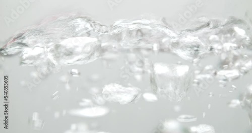 Slow motion of boiling water on a white background.