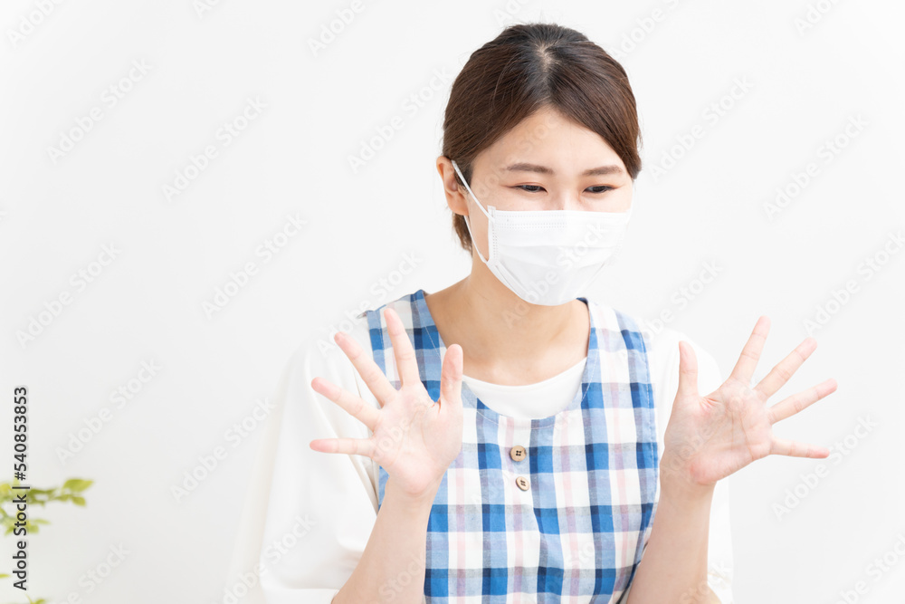 マスクをつけて笑顔で手を振る保育士