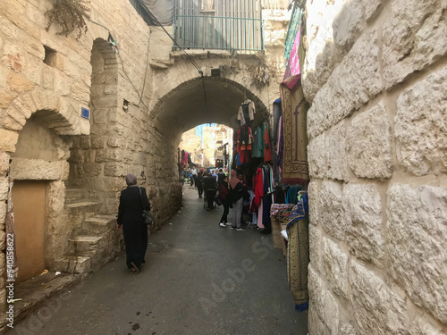 Bethlehem  Palestine  November 2019 - A group of people walking down a street next to a stone wall