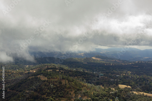 low storm clouds over forested hills