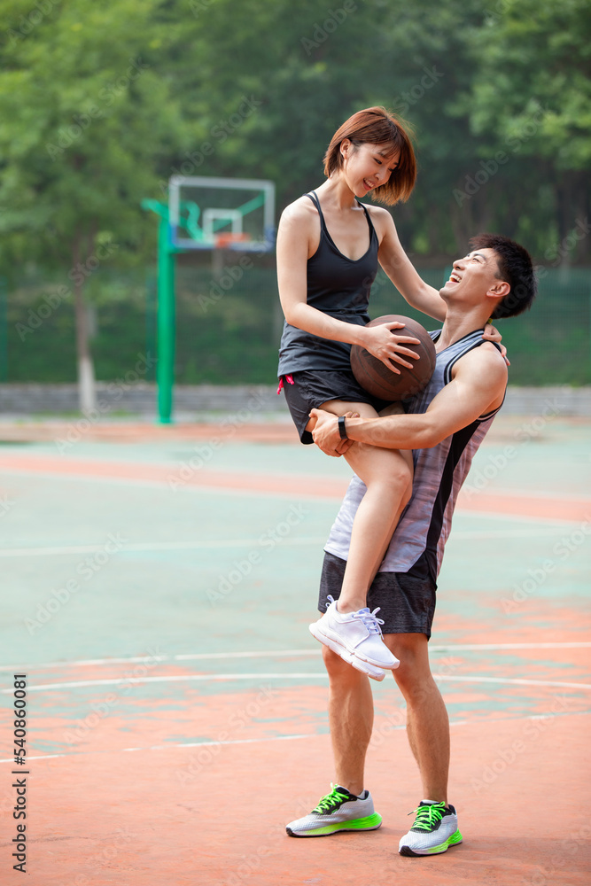 Happy young couple playing basketball outdoors Happy young couple playing basketball outdoors
