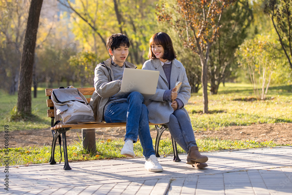 Happy college students using laptop on campus Happy college students using laptop on campus