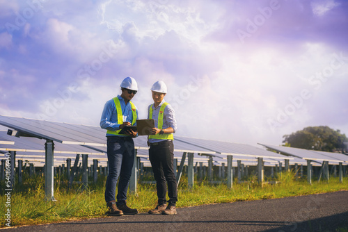 Electrical, instrument technician survey, checking, maintenance electric system at solar panel field in sunny day.