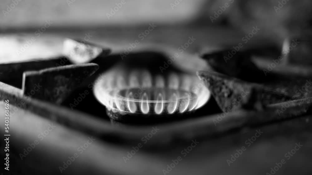 Unstable combustion of gas in the burner of an old gas stove in a deplorable state. A black and white video of a burning natural blue fuel in a rural slum. Low quality of life, poverty and heating Unstable combustion of gas in the burner of an old gas stove in a deplorable state. A black and white video of a burning natural blue fuel in a rural slum. Low quality of life, poverty and heating