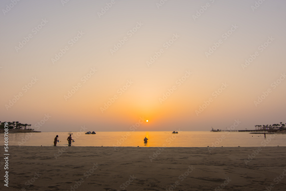 snorkelers during a warm sunrise at the sea snorkelers during a warm sunrise at the sea
