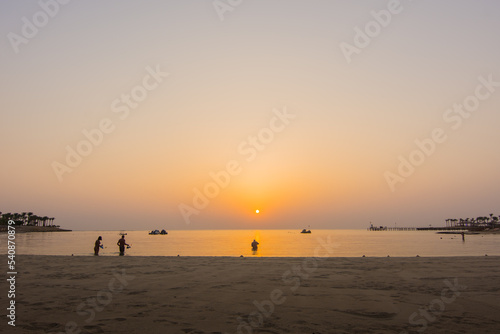 snorkelers during a warm sunrise at the sea