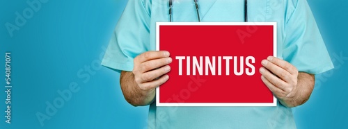 Tinnitus. Doctor shows red sign with medical word on it. Blue background. photo