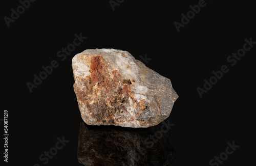 The mineral cerussite is gray in color with a dirty reddish coating on the surface photo