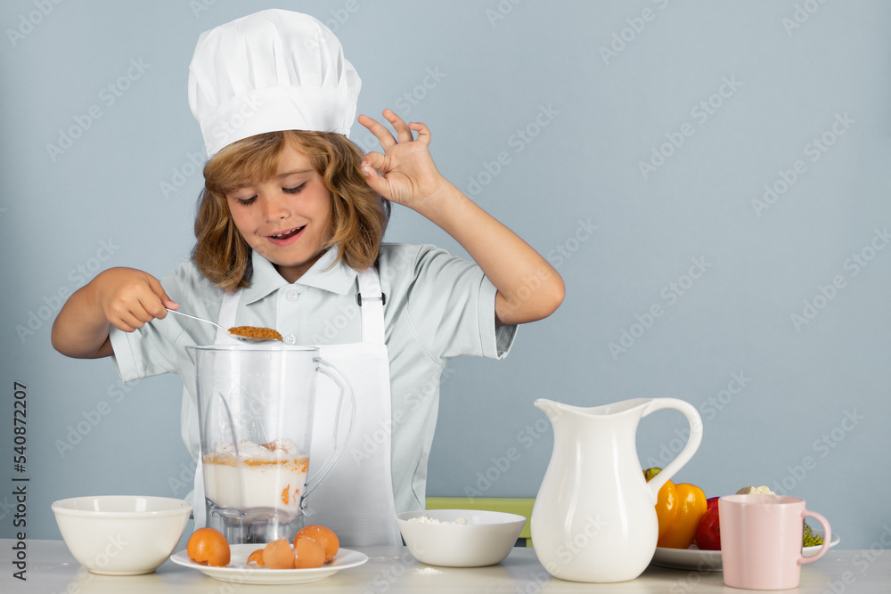 Child chef dressed cook baker apron and chef hat isolated on studio background. Healthy nutrition kids food. Child chef dressed cook baker apron and chef hat isolated on studio background. Healthy nutrition kids food.