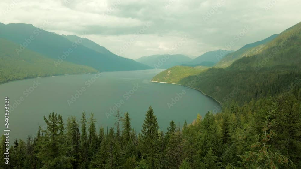 Slow aerial dolly through a dense forest revealing the stunning Slocan Lake Slow aerial dolly through a dense forest revealing the stunning Slocan Lake
