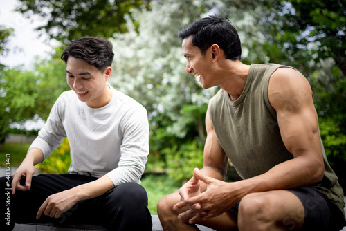 Asian young man talking together in park. Concept for outdoor lifestyle and enjoy life. © Panithan