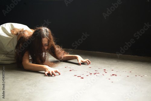 Happy Halloween day in Scary ghost woman. Asian ghost or zombie horror creepy scary have hair covering face and eye reach arm out at abandoned house dark room. 