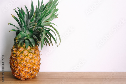 pineapple on a wooden table against white background