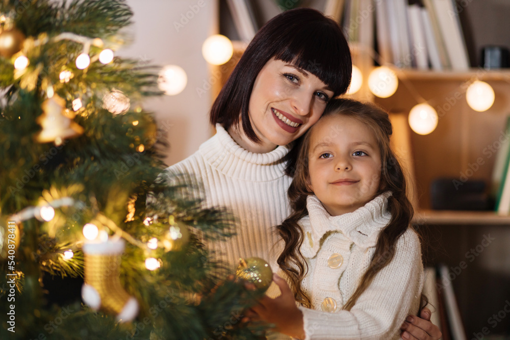 Mother and daughter holding decoration for Christmas tree. Stylish interior of a children's room. Scandinavian eco-style decor. New Year celebration. Christmas eve. Support joint time forwarding. love Mother and daughter holding decoration for Christmas tree. Stylish interior of a children's room. Scandinavian eco-style decor. New Year celebration. Christmas eve. Support joint time forwarding. love