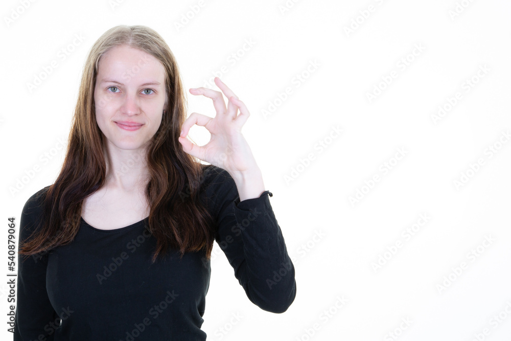 Obraz premium Attractive woman posing in studio showing ok sign on copy space white background
