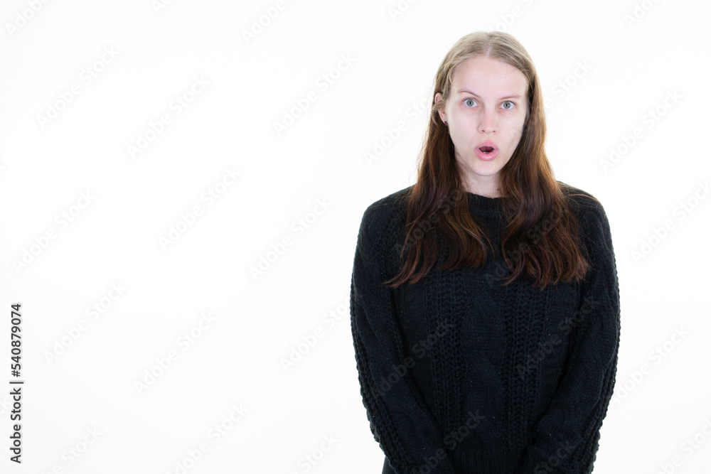 young and pretty woman in black sweater surprised with open mouth aside copy space on white background young and pretty woman in black sweater surprised with open mouth aside copy space on white background