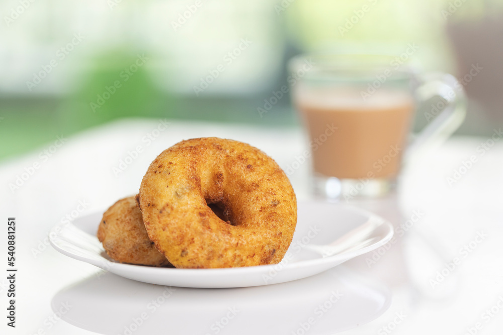 plate of methu vadai with cup of tea on table. plate of methu vadai with cup of tea on table.