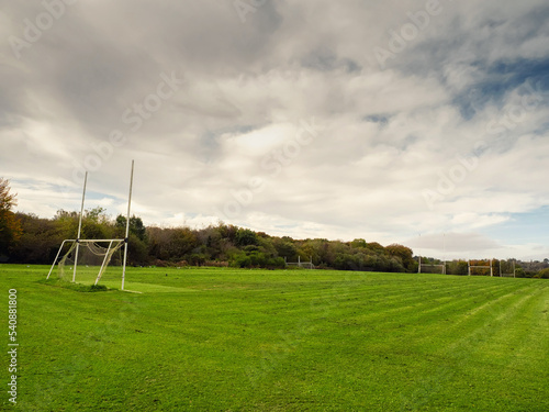 Training pitch for Irish National sport camogie, hurling, rugby and Gaelic football with tall goal posts and freshly cut grass. Nobody. Cloudy sky. Popular activity.