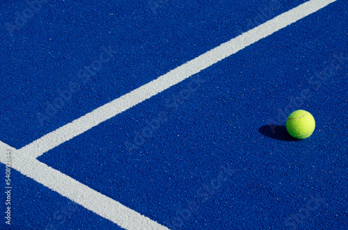 an isolated ball on a blue paddle tennis court, racket sports © Vic