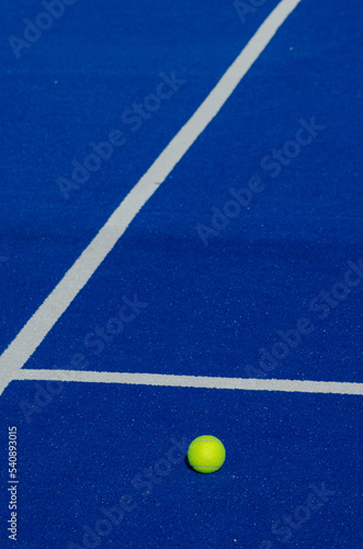 a ball on a blue paddle tennis court, racket sports concept © Vic