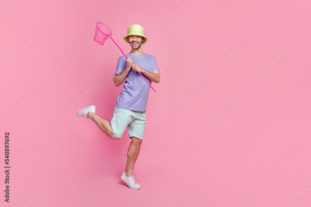 Full length of attractive overjoyed person arm hold insect net toothy smile free time empty space isolated on pink color background Full length of attractive overjoyed person arm hold insect net toothy smile free time empty space isolated on pink color background