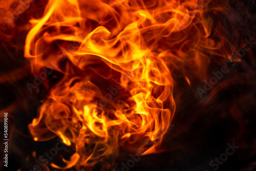Burning fire close up. Bright orange and red flames on a dark background. Open flame heating. Problems with heating and gas.