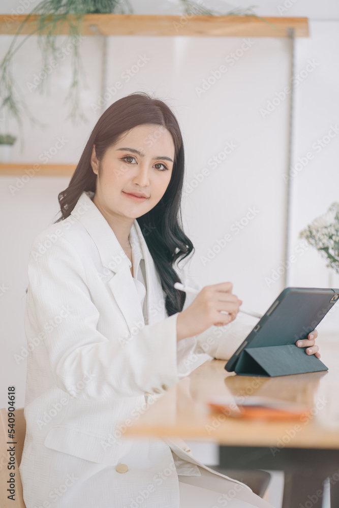 Portrait of smiling beautiful business asian woman working in modern office desk using tablet laptop computer, Business people employee freelance online marketing e-commerce telemarketing concept.
