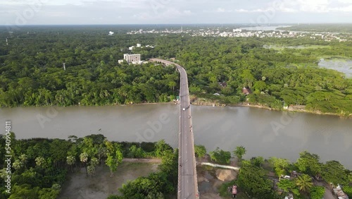 Bridge connects riverbank villages from two district in Bangladesh. Urbanization concept. Aerial Drone shot photo