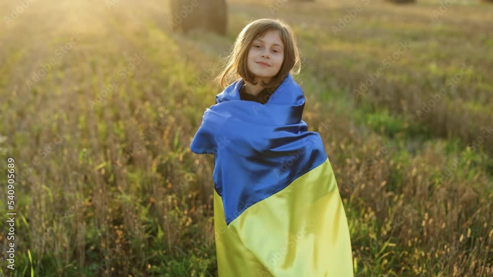 Portrait of little girl holding a yellow and blue flag of Ukraine on a ...