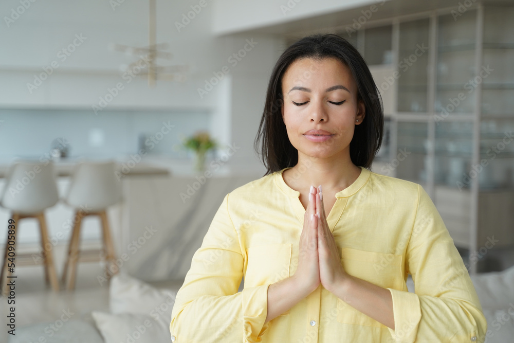 Female makes namaste yoga gesture, keeping calmness, praying at home. Meditation, stress relief Female makes namaste yoga gesture, keeping calmness, praying at home. Meditation, stress relief