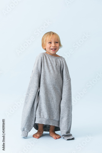 Laughing happy little blond boy in overside hoodie photo