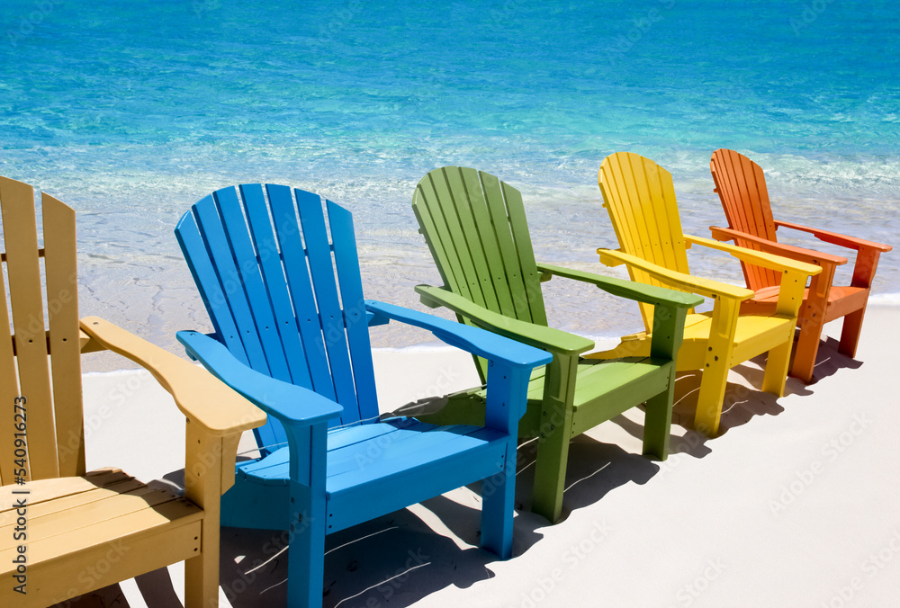Colorful wooden chairs on white sand beach