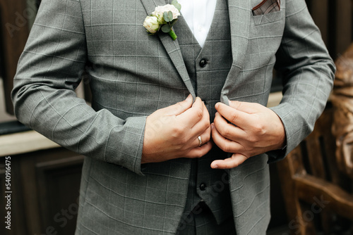Elegant man in a suit adjusts his jacket, business and wedding concept